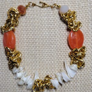 A handmade orange and gold bracelet featuring carnelian-like beads, white mother-of-pearl chips, a small white daisy charm, and a gold chain.